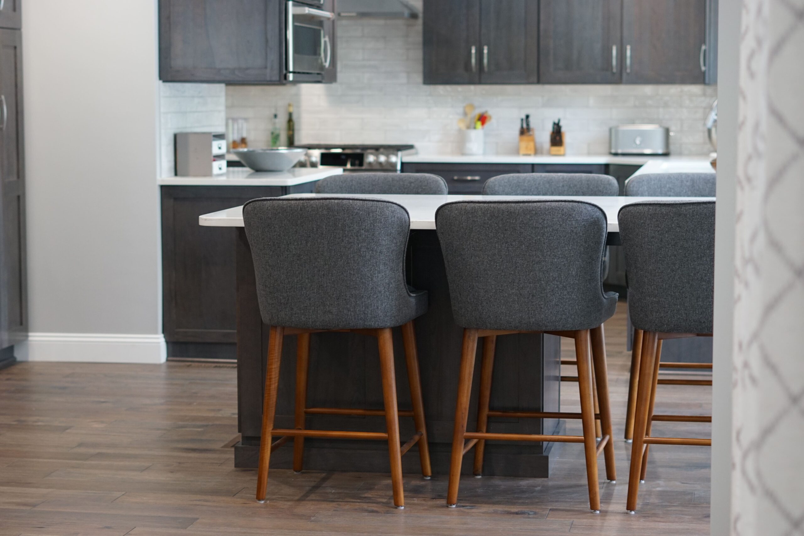 grey cloth chairs at white kitchen counter