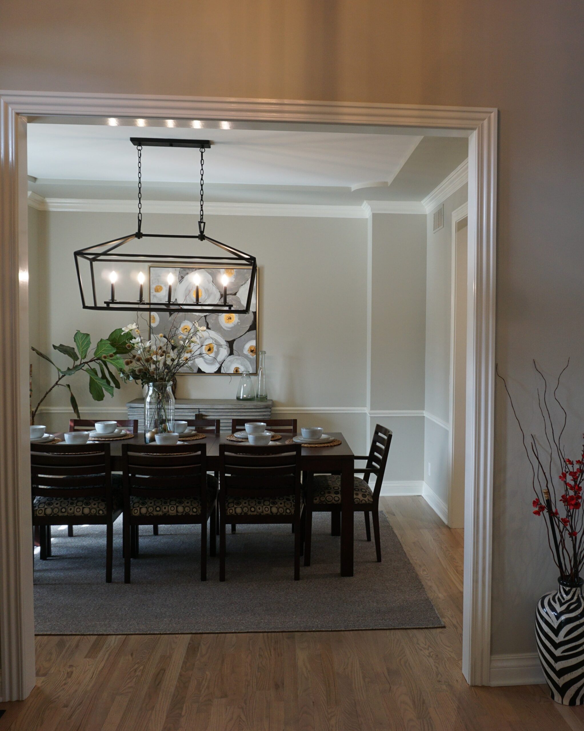 white dining room with brown table and hanging lights