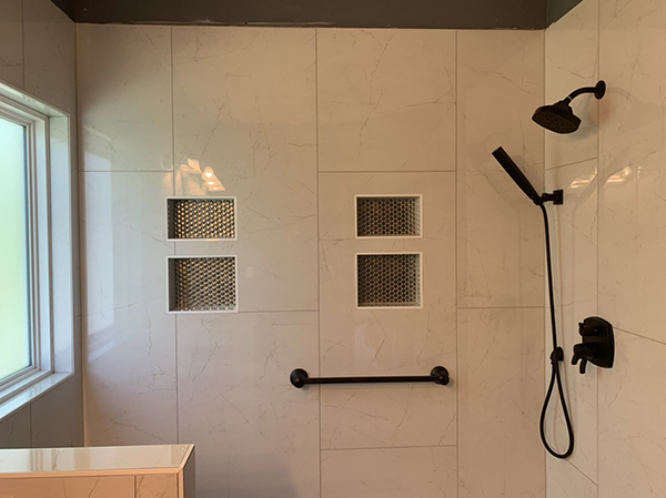 white tile shower with black shower head
