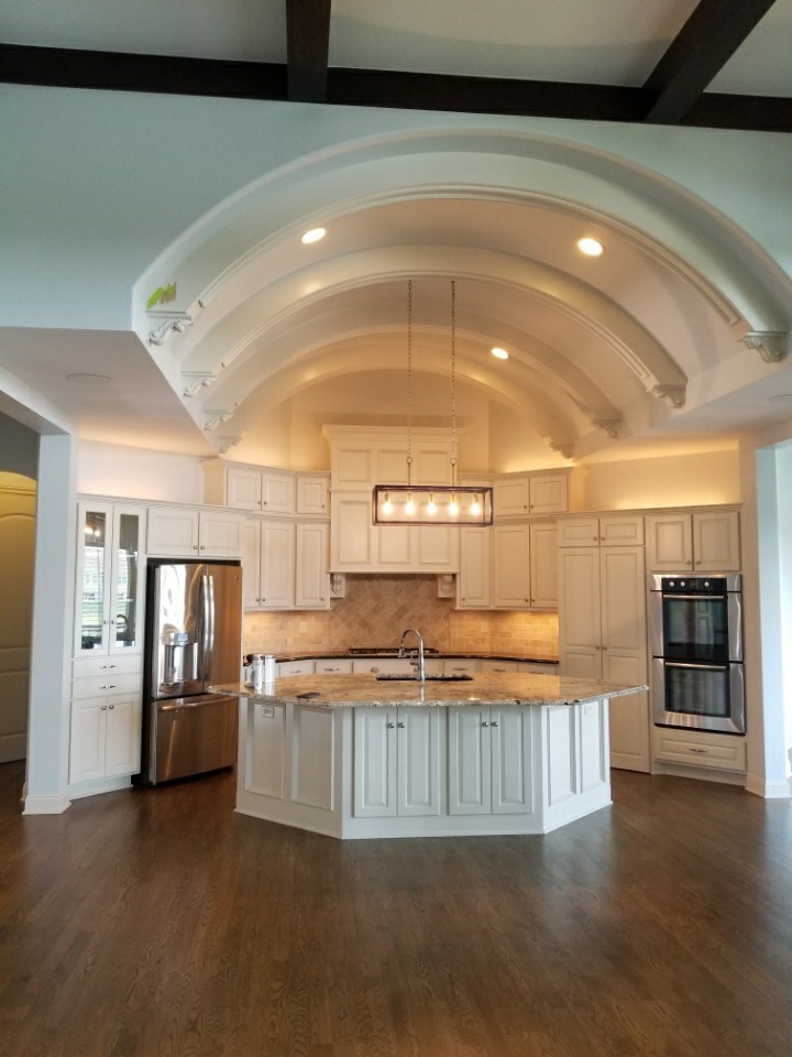 large kitchen with tall ceiling and hanging lights