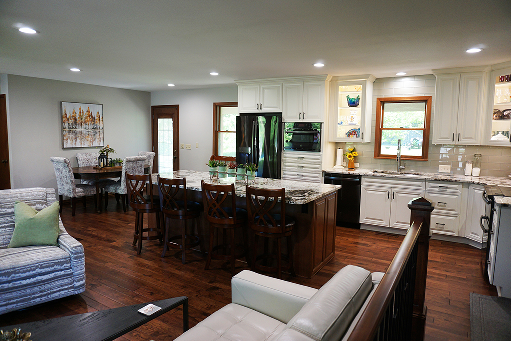 wooden living room and kitchen with white cabinets