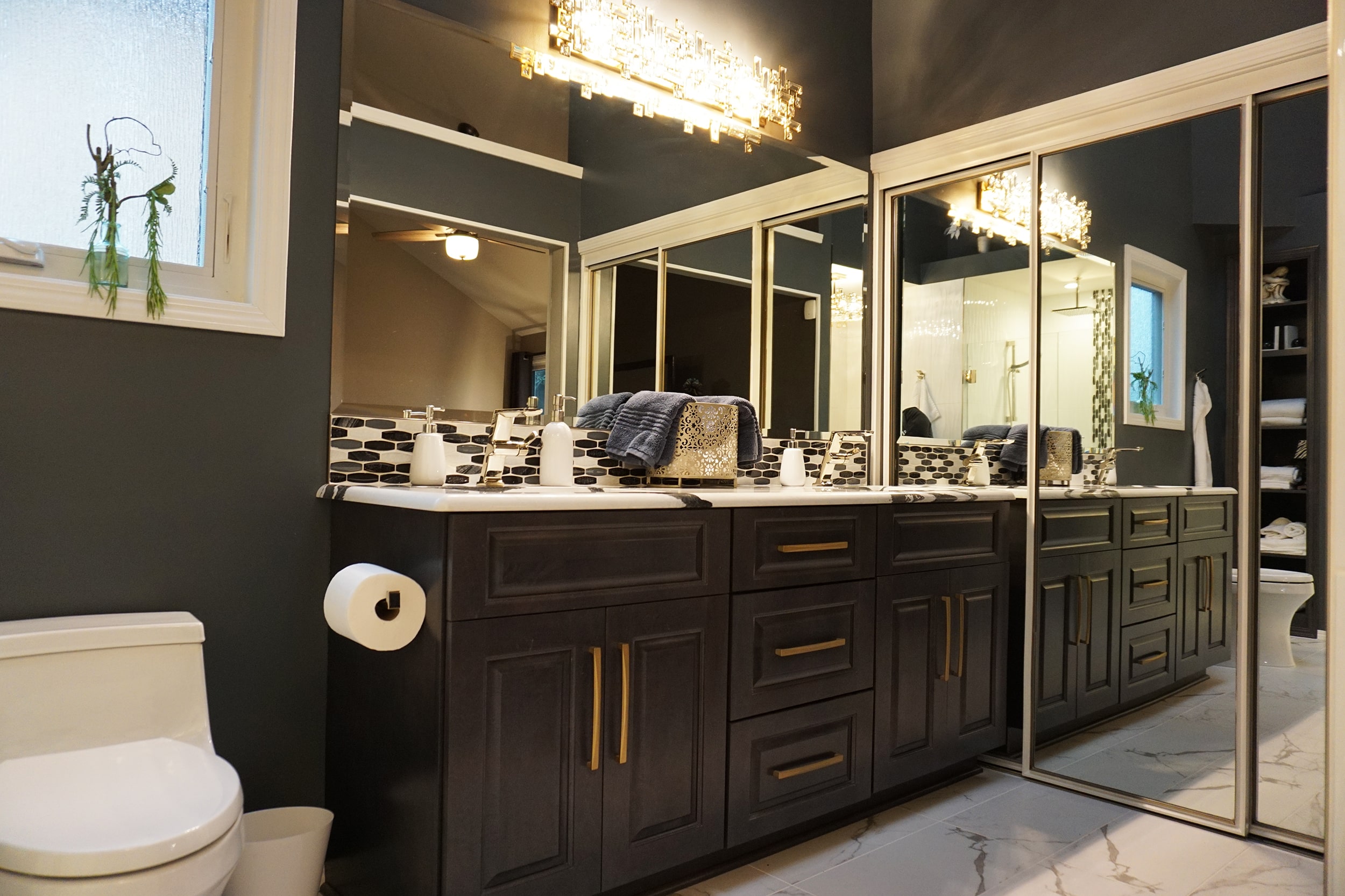 Bathroom with mirrors and black cabinets
