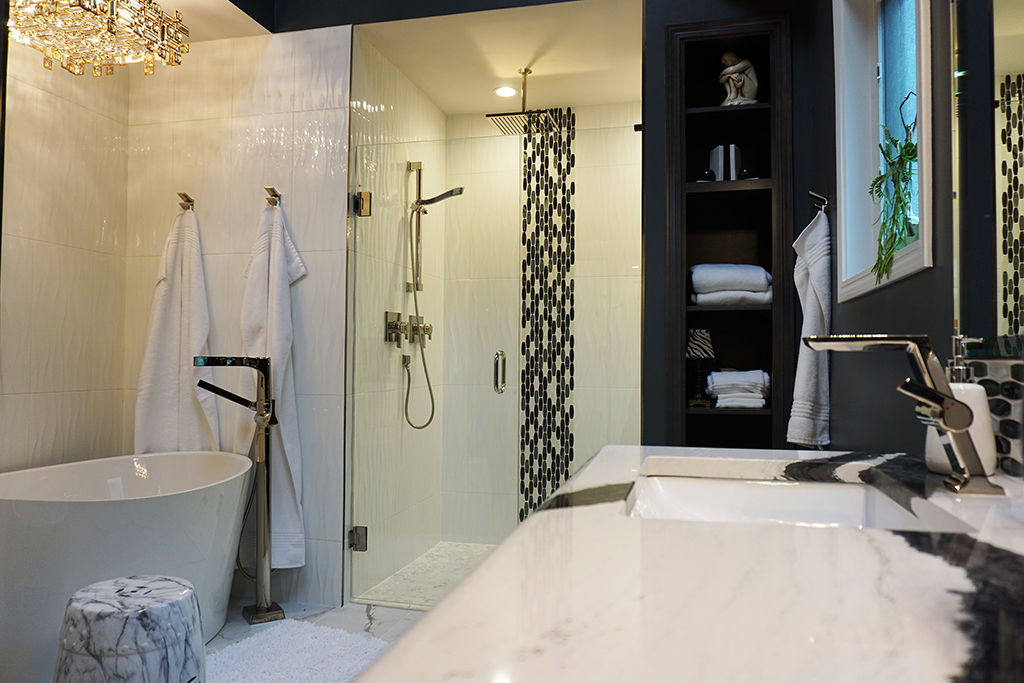 black bathroom with white bathtub and standing shower
